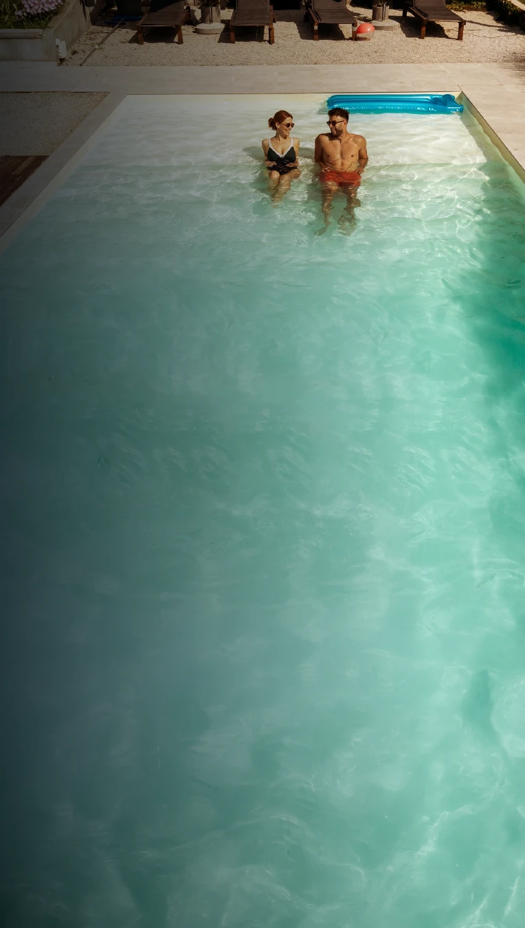 Casal na Piscina Granitada® Fiber com deck de madeira ao lado